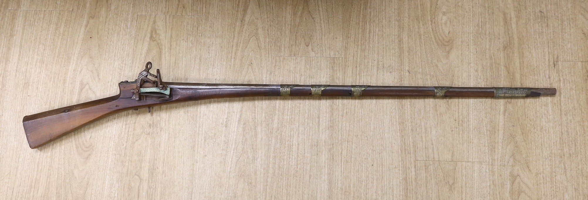 An Eastern decoratively metal mounted antique musket, 132cms long.